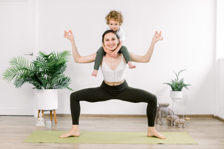 Mother and son doing fitness yoga exercise at home. Charming family spends time in the gym, mother...