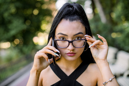 Close-up cropped shot of pretty confident Asian woman with black ponytail hairstyle and eyeglasses,...