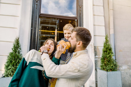 Happy family, father, mother and cute child boy, standing together and having fun outdoors, enjoying...