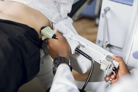 Extracorporeal shockwave therapy in urology. Cropped shot of belly of woman patient, having ultrasound to determine kidney stones position before the lithotripsy procedureの写真素材