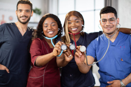 Blur front view of four young diverse multiethnic medical practitioners, standing together in light...
