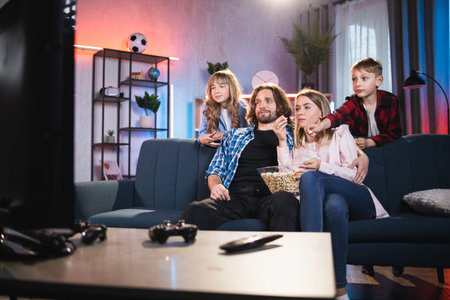 Family entertainment and unity. Relaxed happy smiling parents and their two cute kids boy and girl,...