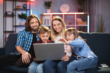Front view of happy cheerful smiling loving family with two kids, watching movie or revisioning...