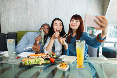 Selfie time, lunch and friendship concept. Pretty red haired girl taking a picture by the cell phone...