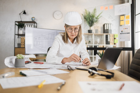 Competent mature female engineer, designer or architect leading working conference at office center....