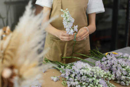Gardeners in the flower shop make bouquet for a holiday. Family flowers business. Lifestyle flower...