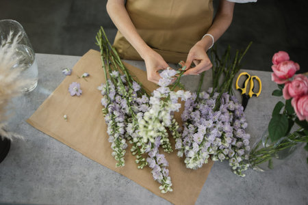 Gardeners in the flower shop make bouquet for a holiday. Family flowers business. Lifestyle flower shop. Beautiful flower composition. Detail. Close up.の写真素材