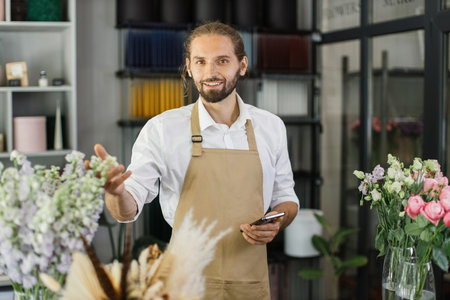Man florist at her own floral shop taking care of flowers. People, business, sale and floristry...