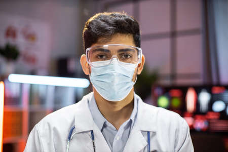Portrait of professional indian man microbiologist or medical worker using protective mask in the laboratory.の写真素材