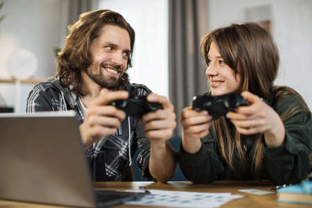 Games, entertainment, family, leisure concept. Close up of young caucasian family, holding joysticks and enjoying their free time playing new games at home.の写真素材