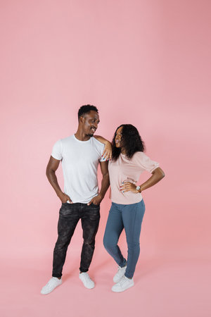 Full length view of stylish african american woman in casual outfit leaning on man standing with...