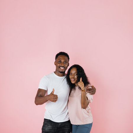 Photo below belt of cheerful people of exotic appearance on isolated pink wall. African female with...
