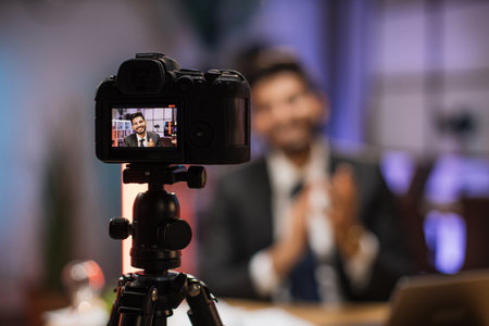 Focus on camera screen of smiling successful arab skilled bearded businessman in formal wear recording new video for his internet business course and clapping hands.の写真素材