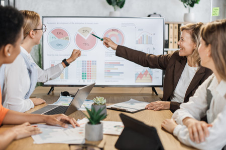 Multi ethnic team of female brokers spending time at office for making strategy of successful...
