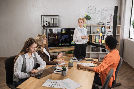 Multiracial female business people having briefing about financial situation at company. Caucasian...