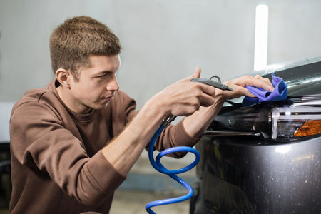 Car wash and cleaning at professional auto service station. Close up view of caucasian young male...
