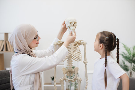 Therapist having fun with skull near preteen girl at workの写真素材