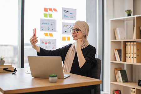 Employee with phone clenching fist in joy of ideal dealの写真素材