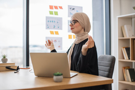 Muslim worker practicing yoga for easing stress in officeの写真素材