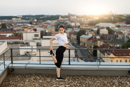 Lady warming-up legs before training on gravel roof