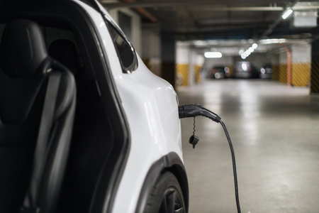E-car back part with charging cord in port in parking lotの写真素材