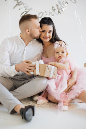 Spouse with baby girl sharing birthday happiness togetherの写真素材