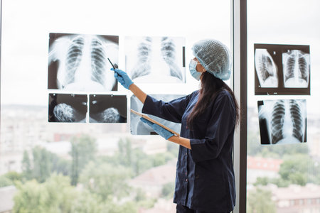Surgeon with tablet examining x-ray scan of patient chest