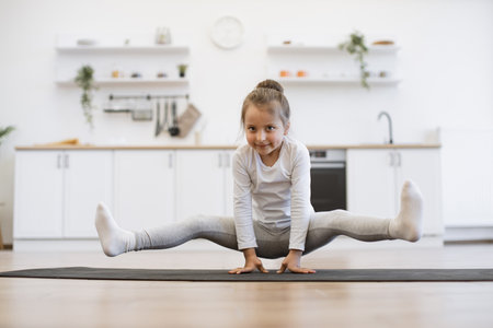 Little cute girl practicing yoga, standing in crane exerciseの写真素材