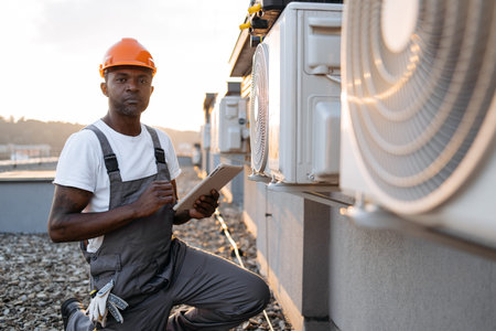 Man in uniform using digital tablet for air conditioners