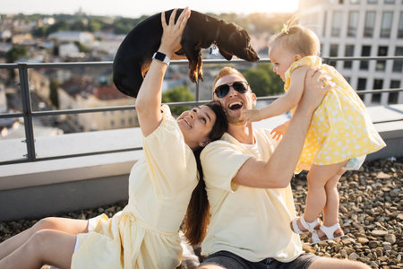 Mom and dad playing with baby and dog on roof of building
