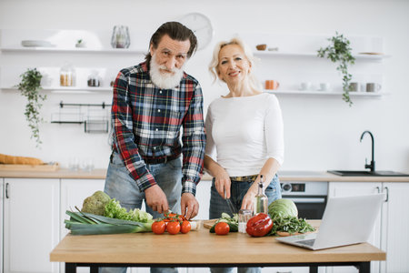 Caucasian old married man and wife prepare healthy salad.の写真素材