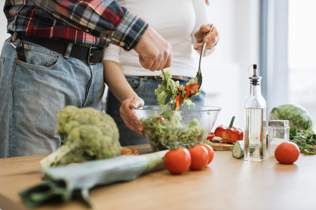 Caucasian old couple spends free time cooking breakfast in modern light kitchen.の写真素材