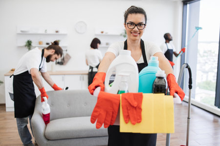 African American woman cleaning worker holding a bucket with detergents.の写真素材
