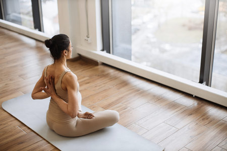 Middle aged women practicing yoga in Lotus pose or Padmasana.