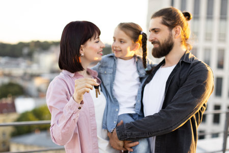 Happy family with new house keys on rooftopの写真素材