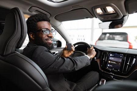 Businessman buying car at dealership sitting inside vehicleの写真素材