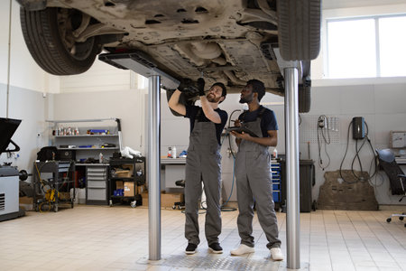Mechanics working on car in auto repair shop