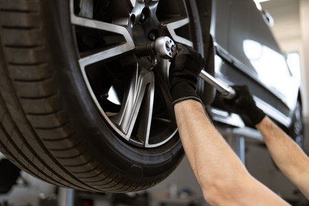 Mechanic working on car tire in auto repair shop