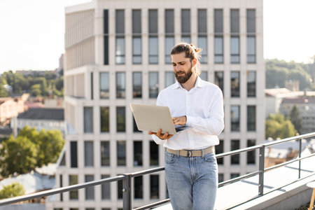 Business professional working on laptop on office rooftop terraceの写真素材