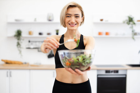 Woman preparing healthy salad in modern kitchen