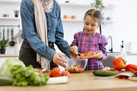 Mother and daughter preparing healthy salad in the kitchenの写真素材
