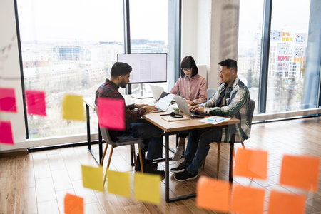 Team collaboration meeting in modern office with sticky notesの写真素材