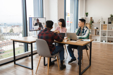 Team participating in video conference meeting at modern office
