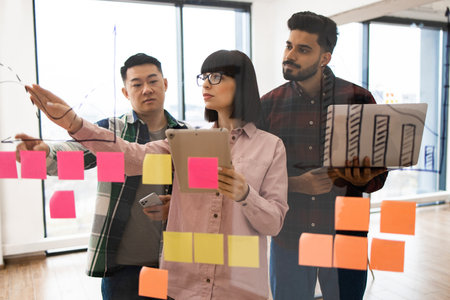 Team brainstorming session with sticky notes and tabletの写真素材