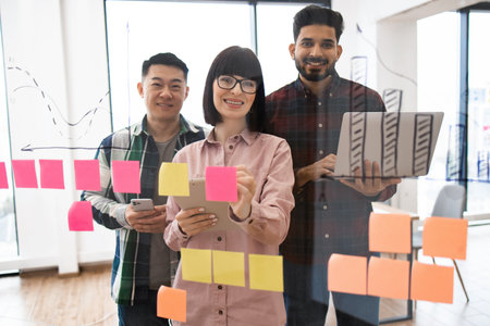 Team brainstorming session with sticky notes and chartsの写真素材