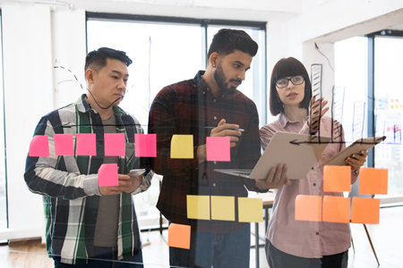 Team brainstorming session with sticky notes and data chartsの写真素材