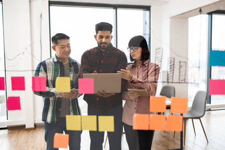 Team collaboration brainstorming with sticky notes and laptopの写真素材