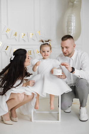 Family celebrating toddlers second birthday with joyful momentsの写真素材