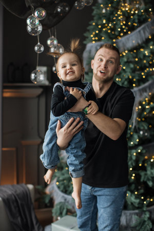 Father and daughter enjoying Christmas at home with decorationsの写真素材