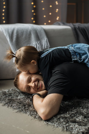 Father and daughter playing on cozy living room floorの写真素材